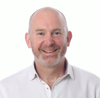 Will Sambrook in a white shirt in front of a white background. 
