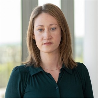 Beth Price in a green top, in front of a window