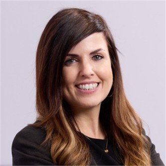 Laura Johnson in a black top, in front of a pale background