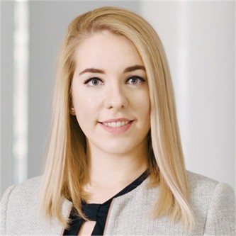 Abaigh Compton in a grey jacket, in front of a pale background