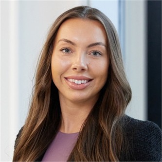 Amber Williams-Newton in a black jacket, in front of a pale background
