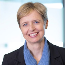 Alison Bull in a dark jacket, in front of a pale background