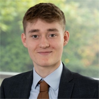 Ben Beardon in a dark suit and tie, in front of a window