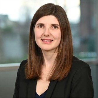 Jennifer Morgan in a black jacket and top, in front of a window