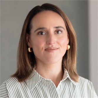 Kelly Westgarth in a white stripy shirt, in front of a grey background
