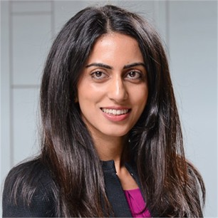 Amandip Dhillon in a dark jacket, in front of a geometric glass background