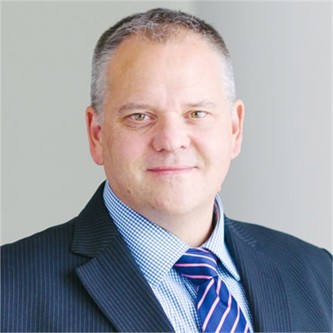 Duncan Astill in a pinstripe suit and tie, in front of a pale background